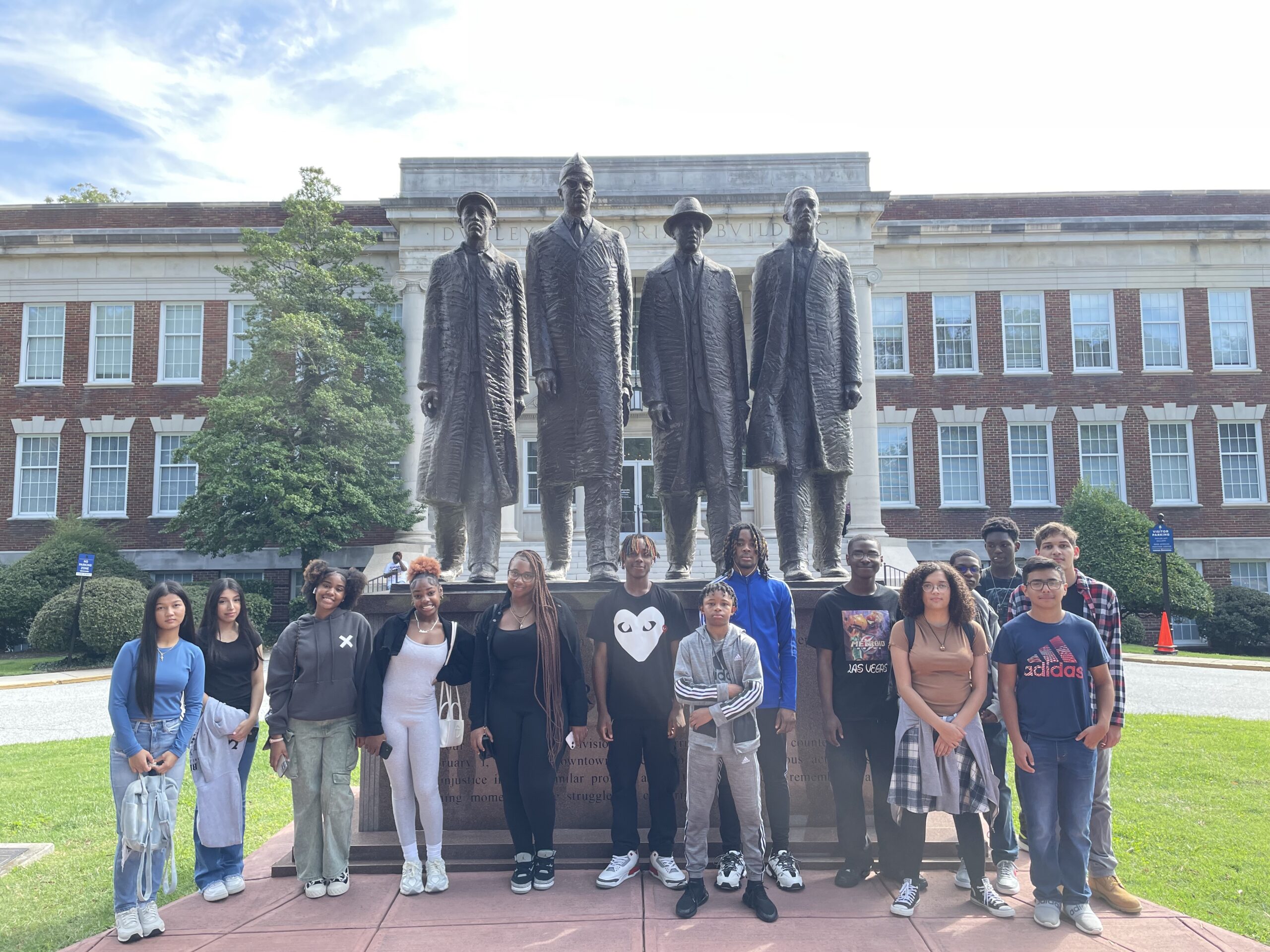 TRIO College Search students stand outside in front of a statue.
